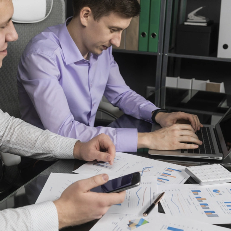dos hombres con portátil revisando factura